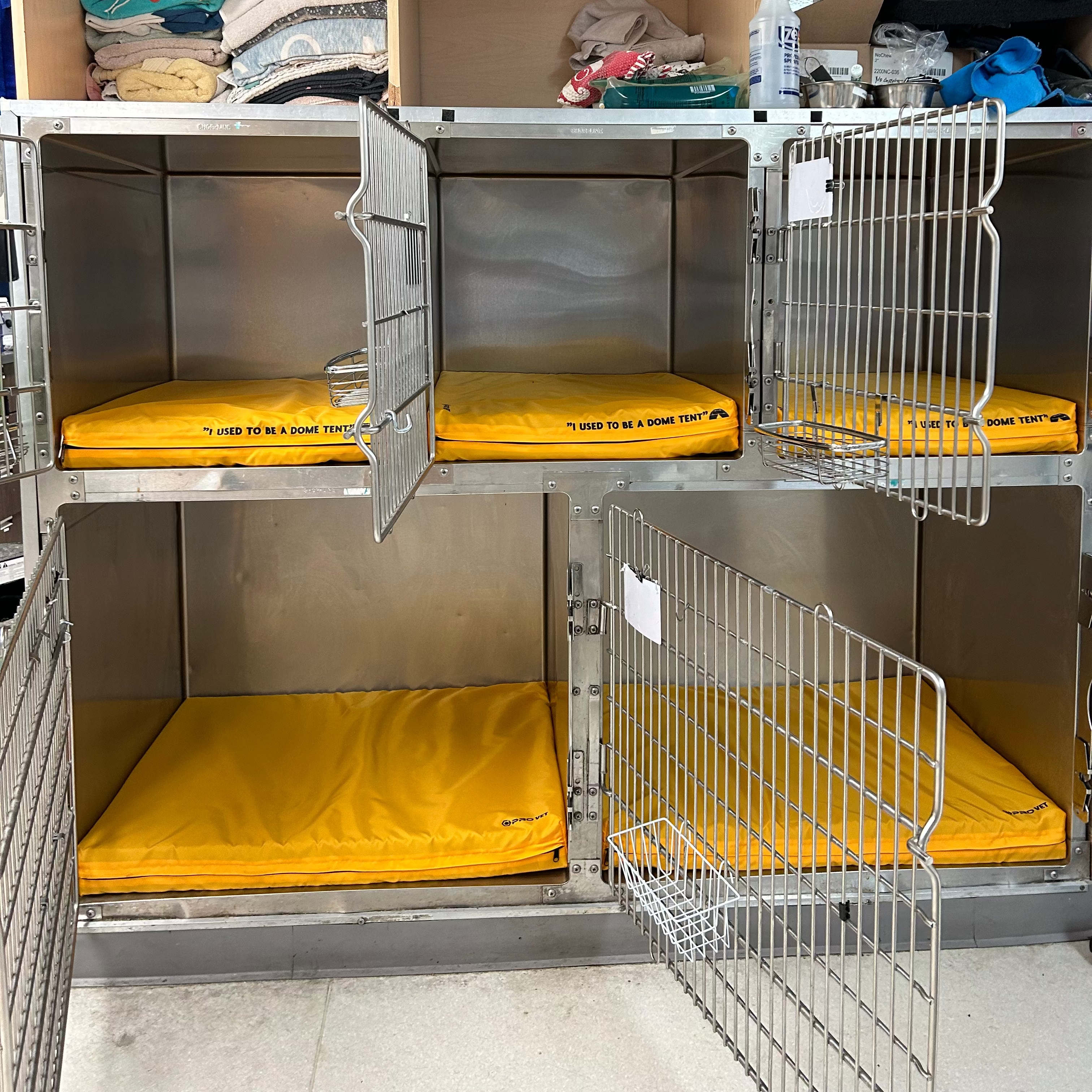 A set of yellow orthopedic recovery cushions with a metal frame, designed for use in veterinary cages and kennels.